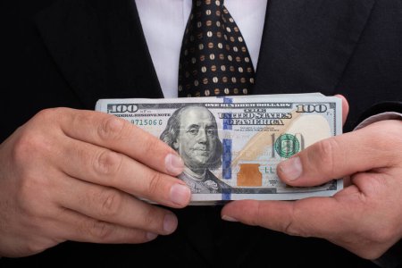 Foto de Manos con billetes en dólares estadounidenses como actividad financiera - Imagen libre de derechos