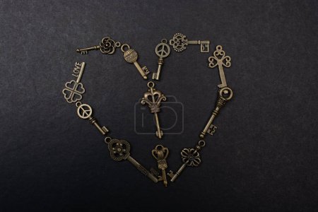 Photo for Retro metal keys form a heart shape om a black background - Royalty Free Image
