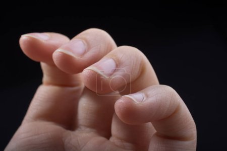 Foto de Cuatro dedos de una mano infantil parcialmente vistos en fondo negro - Imagen libre de derechos