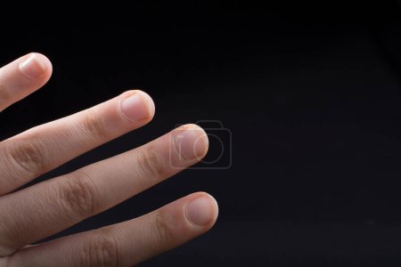 Photo for Four fingers of a child hand partly seen in black background - Royalty Free Image