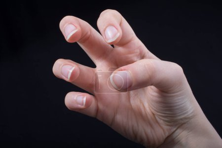 Foto de Cinco dedos de la mano de un niño parcialmente vistos en fondo negro - Imagen libre de derechos