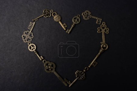 Téléchargez les photos : Clés métalliques rétro forment une forme de coeur om un fond noir - en image libre de droit
