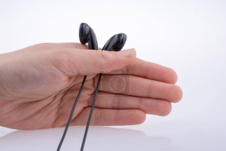 Photo for Hand holding a black earphone on a white background - Royalty Free Image