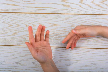 Photo for Hands making a gesture on a wooden background - Royalty Free Image