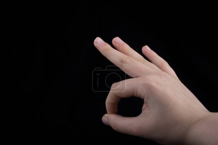 Téléchargez les photos : Signe gestuel main ok ok d'accord sur fond noir - en image libre de droit