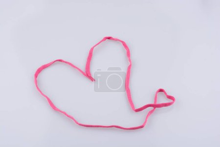 Téléchargez les photos : Coeur façonné à l'aide d'une échancrure rose sur fond blanc - en image libre de droit