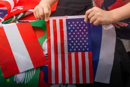Photo for Child hand holding an American national flag in hand - Royalty Free Image