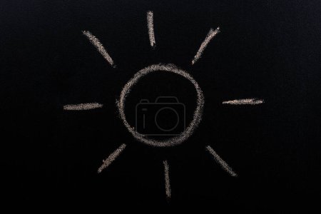 Foto de Sol dibujado a mano por tiza con forma de rayo de luz sobre fondo de pizarra - Imagen libre de derechos