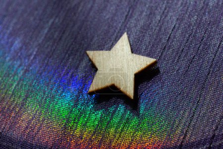 Téléchargez les photos : Forme étoile en bois sur fond de tissu coloré - en image libre de droit