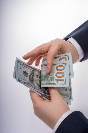 Téléchargez les photos : Homme d'affaires détenant de l'argent en dollars américains sur fond blanc - en image libre de droit