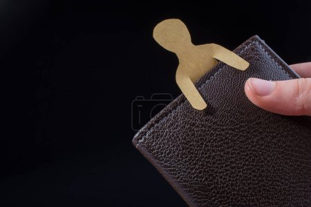 Foto de Forma de hombre cortado de papel en cartera en la mano - Imagen libre de derechos