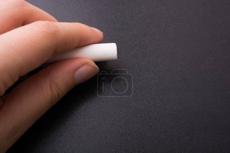 Photo for Hand holding  white chalk and black board - Royalty Free Image