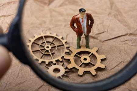 Photo for Little tiny man person figurine  and gear wheel as industry concept - Royalty Free Image