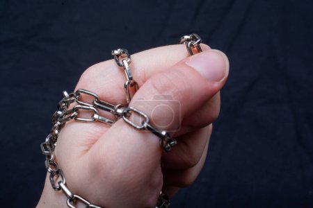 Téléchargez les photos : Une main de femme enveloppée dans une chaîne - en image libre de droit