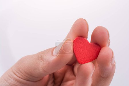 Téléchargez les photos : Main avec un cœur rouge sur fond blanc - en image libre de droit