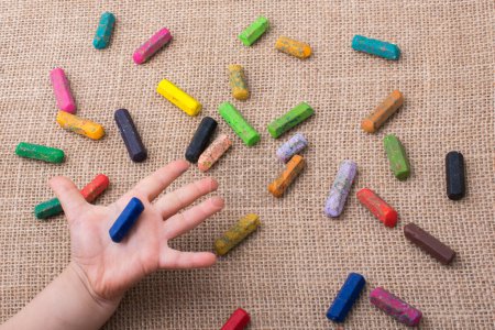 Foto de Crayones de colores usados y una mano de niños pequeños sosteniendo uno - Imagen libre de derechos