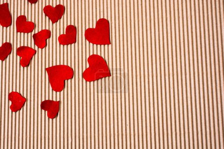 Photo for Red color paper hearts on a brown color cardboard - Royalty Free Image