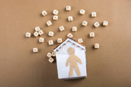 Téléchargez les photos : Cubes de lettre en bois et figurine homme et maison modèle - en image libre de droit