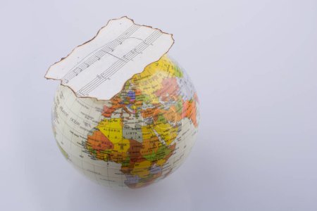 Photo for Musical notes on a burnt paper and a little model globe - Royalty Free Image
