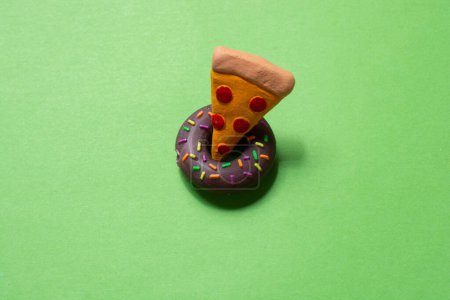 Foto de Pieza de pizza icono de donut icono sobre papel verde. Concepto de cocina - Imagen libre de derechos