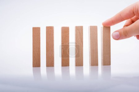 Photo for Hand holding wooden  domino on a white background - Royalty Free Image