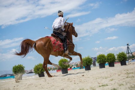 Téléchargez les photos : Cavalier ottoman dans ses vêtements ethniques chevauchant sur son cheval - en image libre de droit