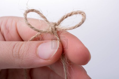 Photo for Thread knot in hand on a light color background - Royalty Free Image
