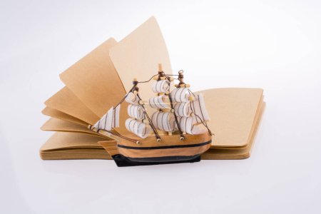 Photo for Old Ship  on a notebook on a white background - Royalty Free Image