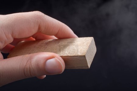 Foto de Pequeño trozo de madera cortada en fondo de mano - Imagen libre de derechos