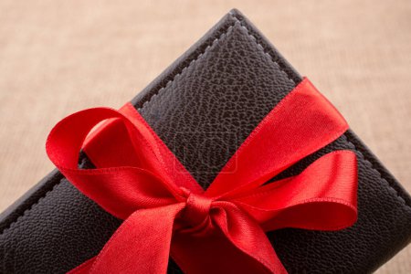 Téléchargez les photos : Portefeuille cadeau enveloppé avec ruban de couleur rouge - en image libre de droit