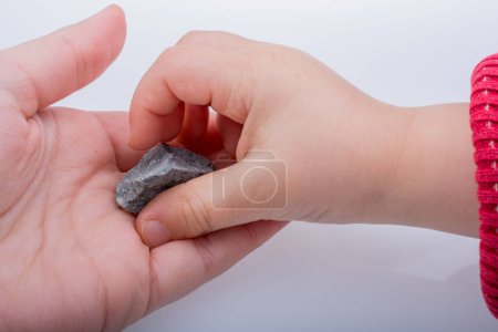 Foto de Mano sosteniendo una pequeña piedra en la mano - Imagen libre de derechos
