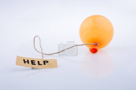 Foto de Palabra de ayuda papel escrito adjunto a un globo con una cuerda - Imagen libre de derechos