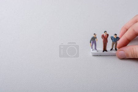 Foto de Pequeñas figuritas de los hombres modelo en miniatura en la mano - Imagen libre de derechos