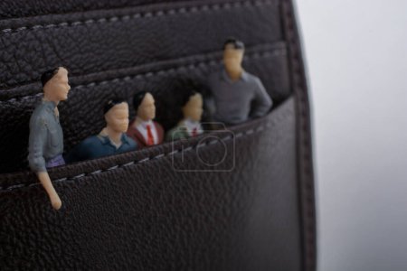Photo for Tiny figurine of group of men miniature model in pockets - Royalty Free Image