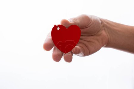 Photo for Heart shaped white object in hand on white background - Royalty Free Image