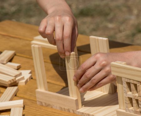 Téléchargez les photos : Main tenant l'élément de puzzle en bois dans la main - en image libre de droit