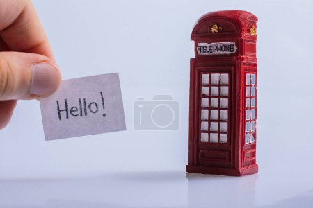 Photo for Notepaper with Hello wording near the telephone booth - Royalty Free Image