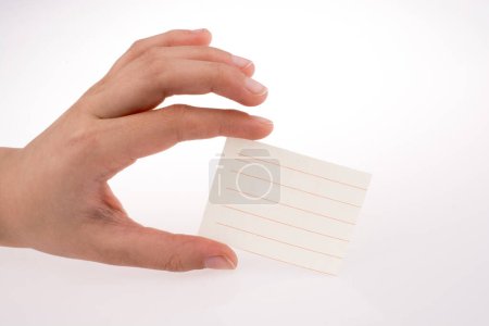 Foto de Mano sosteniendo un pedazo de papel forrado sobre un fondo blanco - Imagen libre de derechos