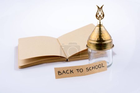 Foto de Lápiz de color, botella de vidrio y de vuelta al título de la escuela en un cuaderno - Imagen libre de derechos