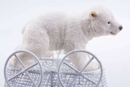 Téléchargez les photos : Petite figure d'ours polaire dans un chariot de bébé jouet en métal sur - en image libre de droit