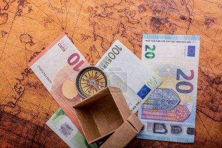 Foto de Brújula, caja y billetes en euros en el mapa como concepto de negocio - Imagen libre de derechos