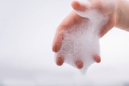Téléchargez les photos : Lavage des mains et mousse de savon sur fond mousseux - en image libre de droit