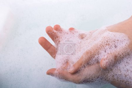 Téléchargez les photos : Lavage des mains et mousse de savon sur fond mousseux - en image libre de droit