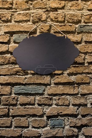 Foto de Tablero de letrero vacío negro con cuerda para colgar en la pared - Imagen libre de derechos