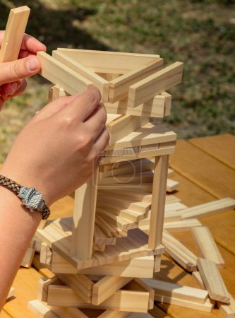 Foto de Mano que sostiene el elemento de madera del rompecabezas en mano - Imagen libre de derechos