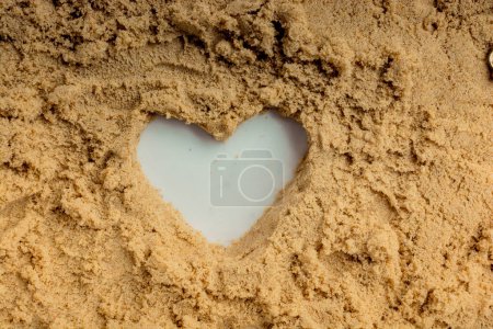 Foto de Llave de estilo retro y una forma de corazón hecha en arena marrón - Imagen libre de derechos