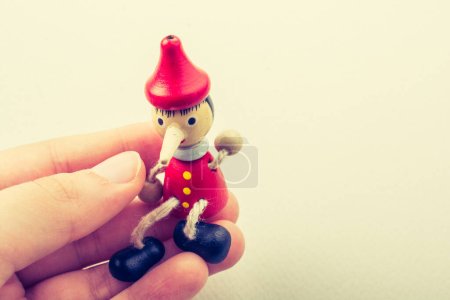 Photo for Wooden pinocchio doll in hand on a white background - Royalty Free Image