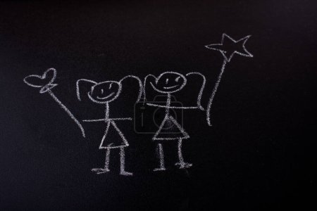Téléchargez les photos : Enfants heureux tenant un ballon dessiné sur de la craie sur un tableau noir - en image libre de droit