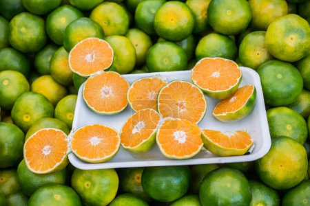 Photo for Freshly picked green tangerines mandarines, clementines, as Citrus fruit background. - Royalty Free Image