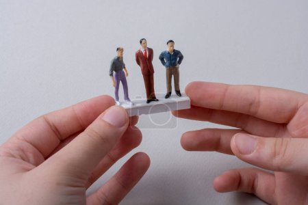 Foto de Pequeñas figuritas de los hombres modelo en miniatura en la mano - Imagen libre de derechos